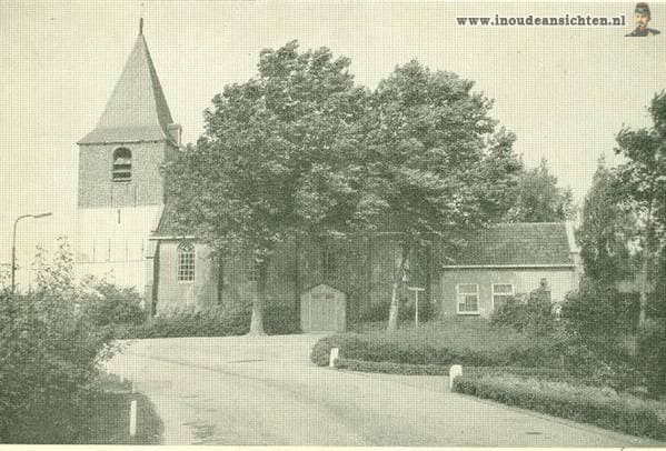 De kerk achter de bomen aan de weg